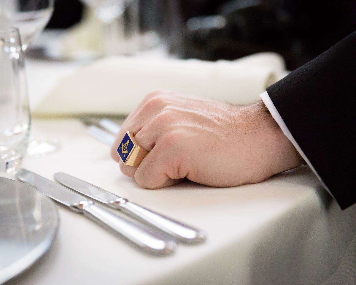 Hand of a Freemason during New Year’s Celebration, Bonn, Germany, 2014. The ring shows the square and compasses, both Masonic symbols.